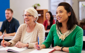 two women in class with notebooks