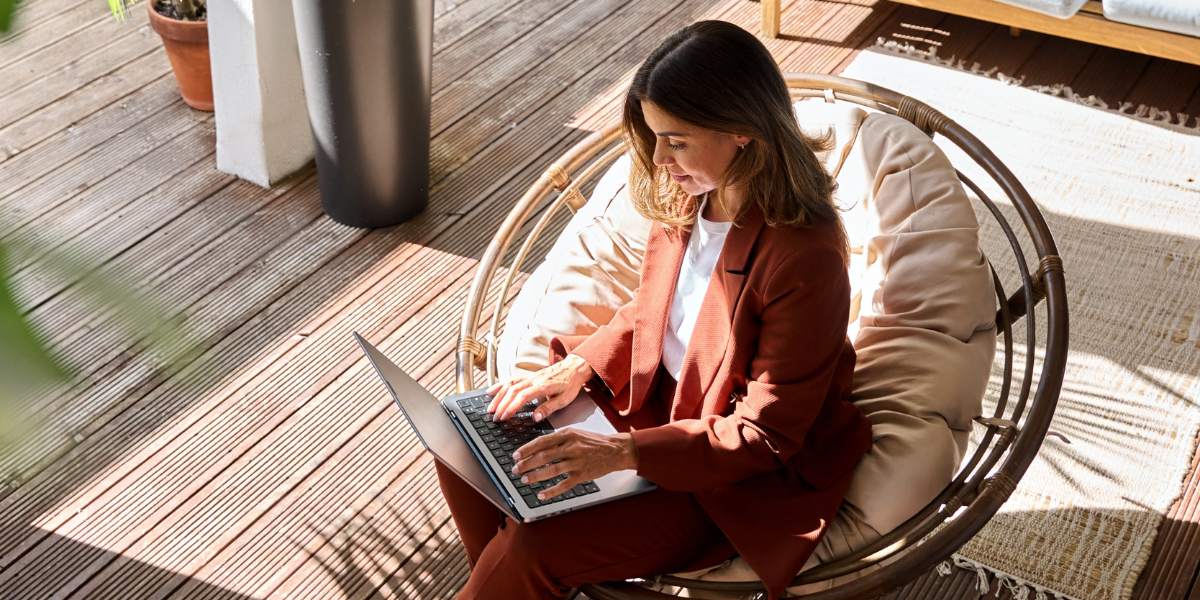 Above angled view of person sitting on chair with laptop open on lap